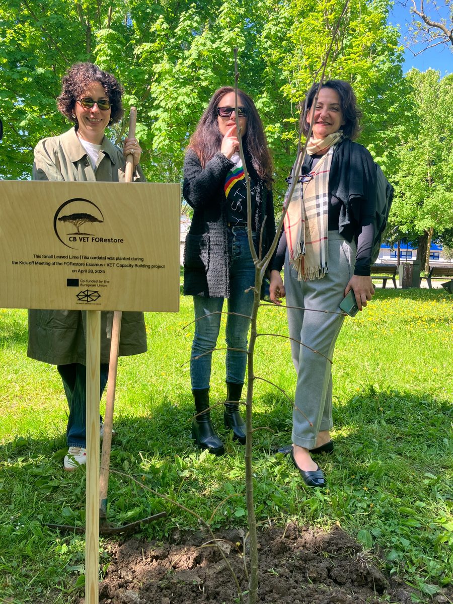 Participants standing near the FORestore project tree and sign